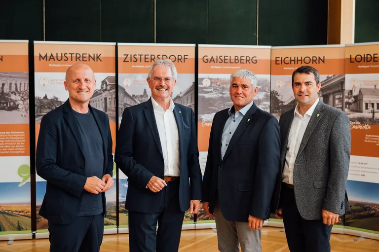 Vier Personen bei einer Pressekonferenz vor Roll-ups mit den Ortsnamen Maustrenk, Zistersdorf, Gaiselberg, Eichhorn und Loidesthal