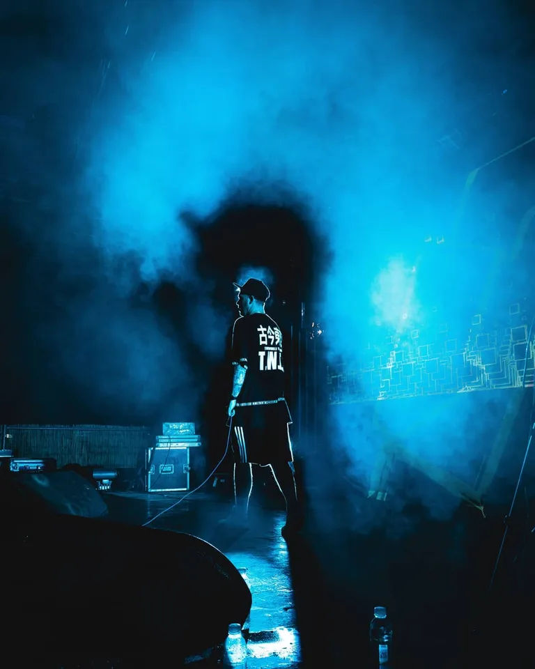 Konzertfotografie: Musiker von hinten im blauen Bühnennebel, Blick in die Halle