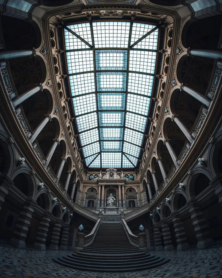 Architekturfotografie: historische Prunkstiege unter einem Glasdach, zentrale Symmetrie