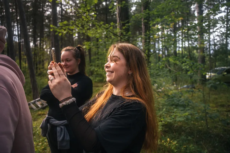 Am Set im Föhrenwald: Crew-Mitglied filmt mit dem Smartphone, daneben eine Kollegin, Musikvideo „Walls“ für AVEC